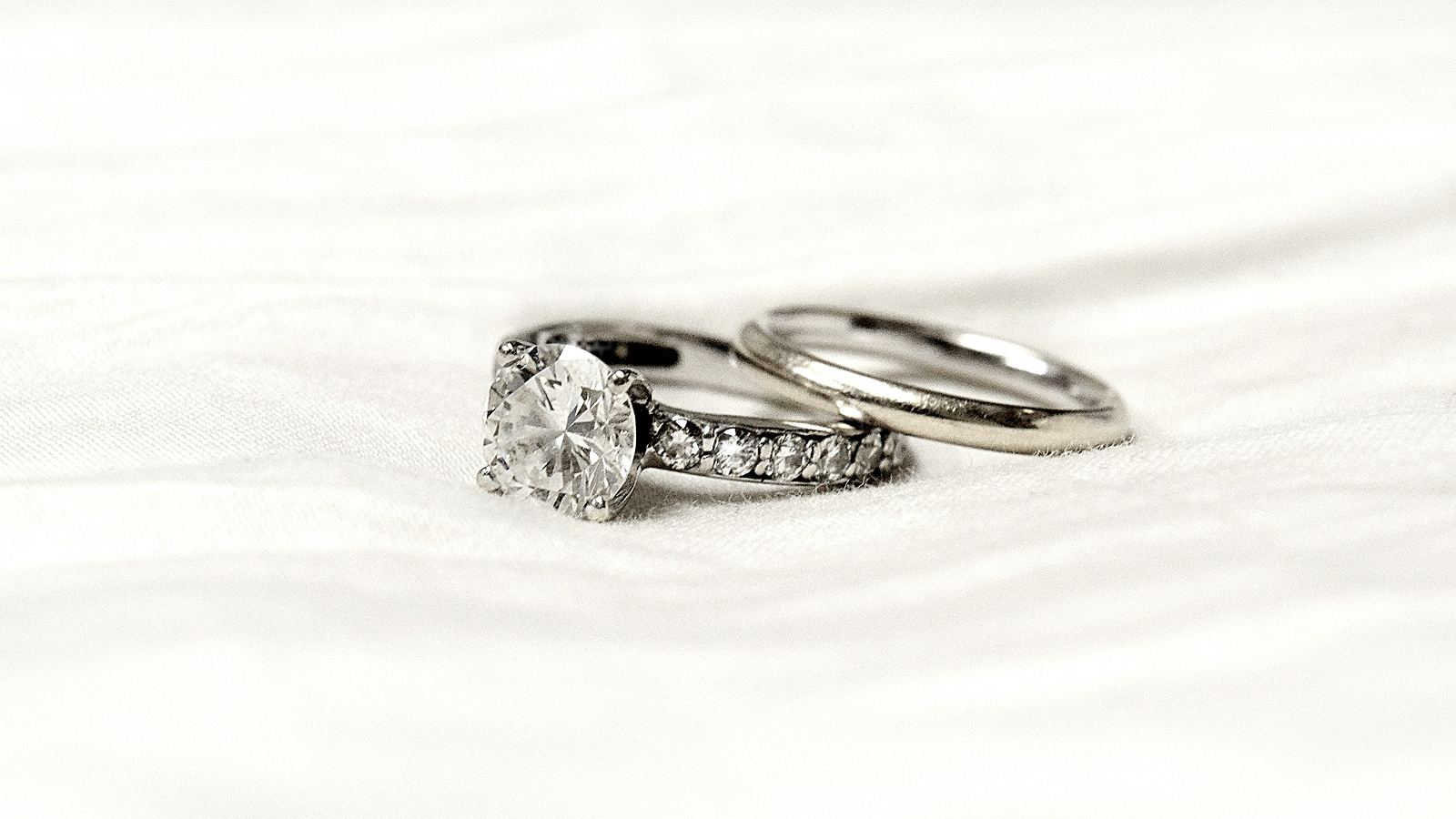 Two silver rings with diamond accents on a white background