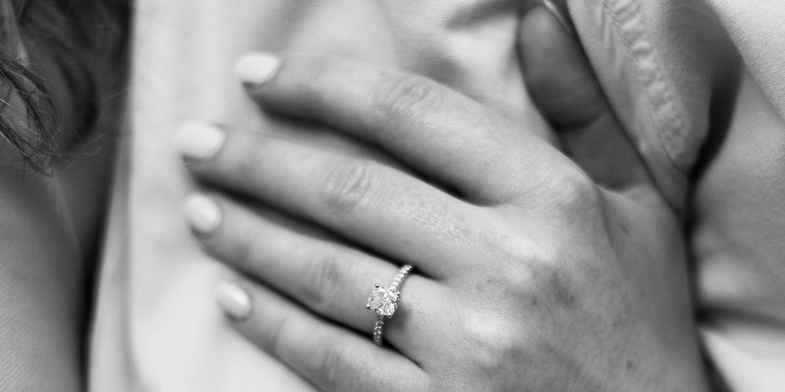 Close-up of a hand with a diamond ring on a blurred background