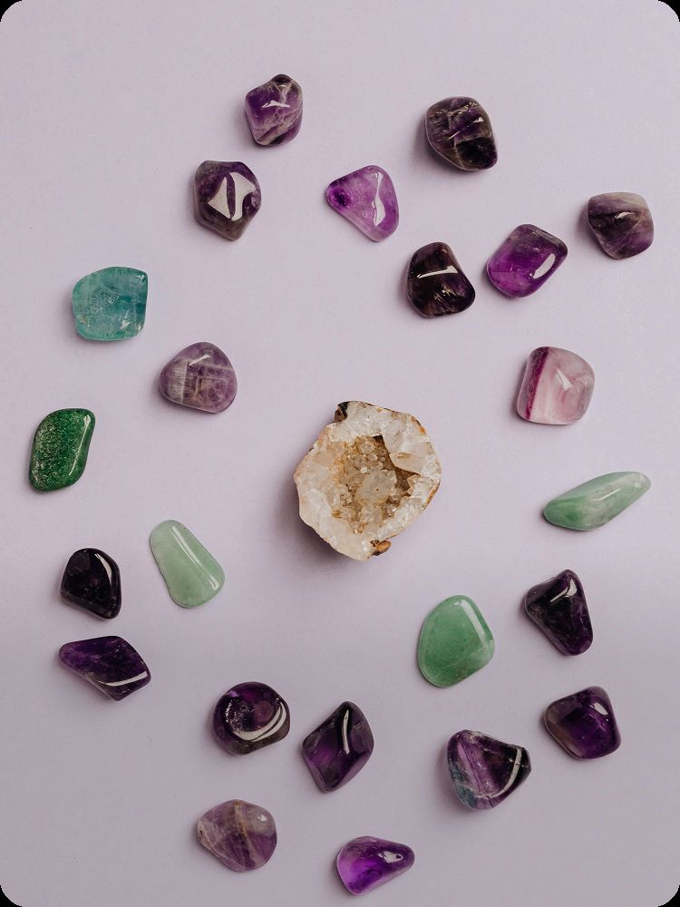 Collection of various gemstones on a light pink background