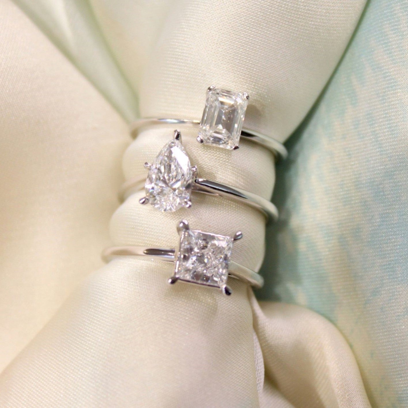 Set of diamond rings on a soft fabric background